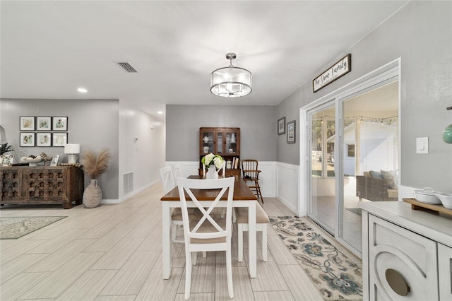 dining space with an inviting chandelier, visible vents, and wood finish floors