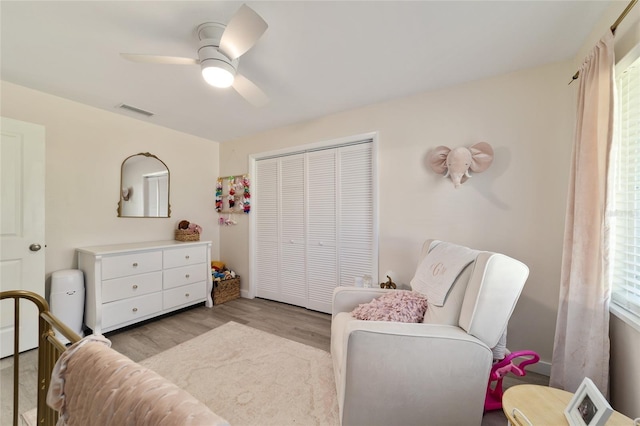 bedroom with ceiling fan, visible vents, a closet, and wood finished floors