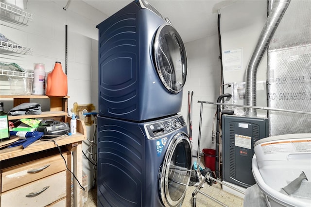 laundry room featuring concrete block wall, laundry area, and stacked washer and dryer