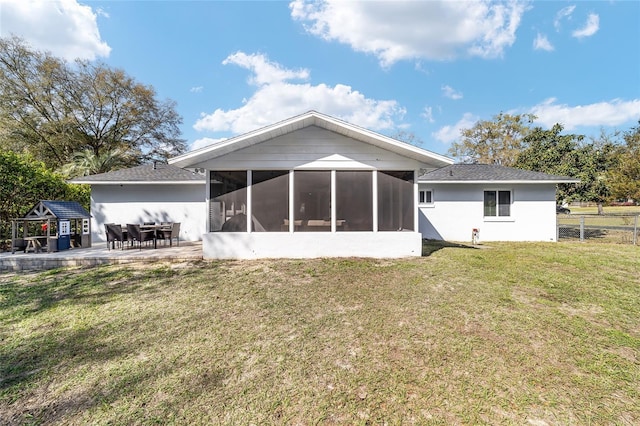 rear view of house featuring a yard, a patio, fence, and a sunroom