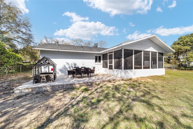 back of house featuring a sunroom, a patio, a lawn, and fence