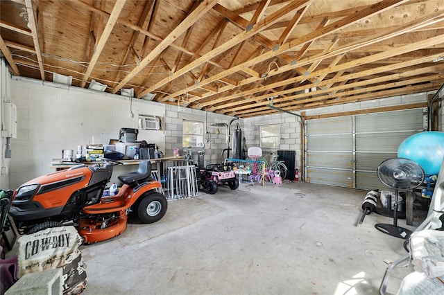 garage featuring concrete block wall and a wall unit AC