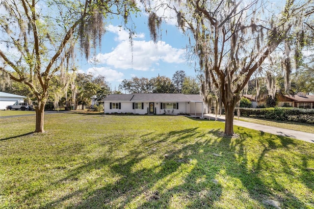 ranch-style house with driveway and a front lawn