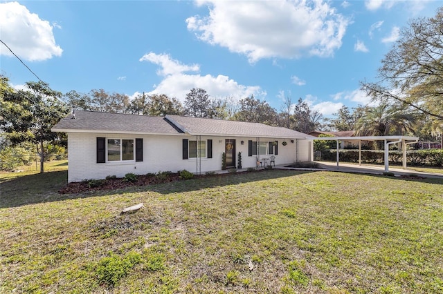 single story home with a carport, brick siding, and a front yard