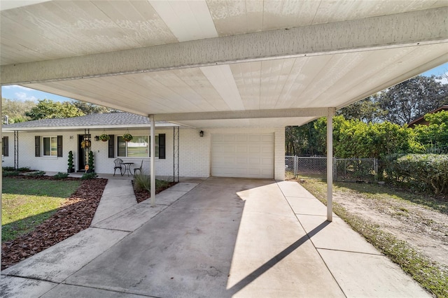 view of patio / terrace featuring an attached garage, covered porch, fence, driveway, and a carport