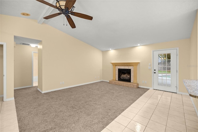 unfurnished living room featuring vaulted ceiling with beams, light tile patterned flooring, a tile fireplace, light carpet, and visible vents