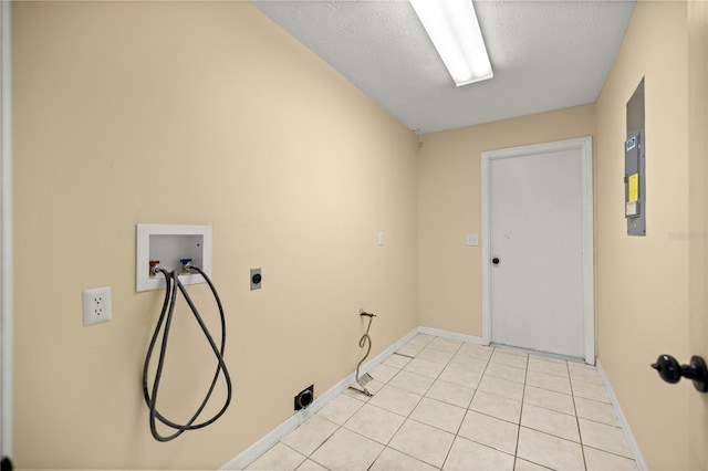 washroom featuring laundry area, light tile patterned floors, baseboards, a textured ceiling, and washer hookup