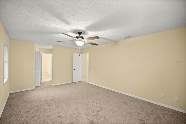 unfurnished bedroom featuring visible vents, baseboards, connected bathroom, a textured ceiling, and carpet floors