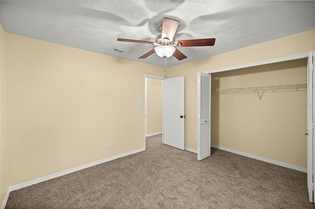 unfurnished bedroom featuring visible vents, baseboards, carpet, a textured ceiling, and a closet