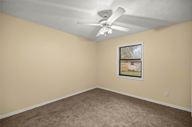 carpeted spare room featuring ceiling fan, baseboards, and a textured ceiling