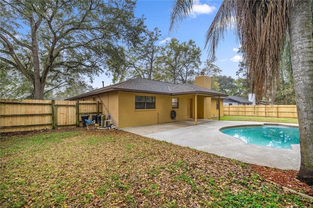 back of property with a patio, a chimney, a fenced backyard, and stucco siding