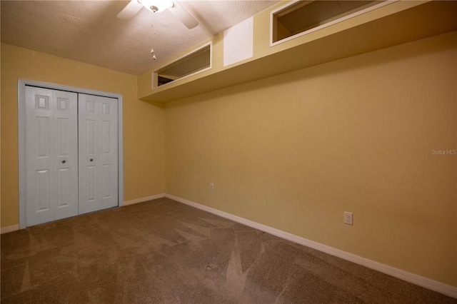 unfurnished bedroom with carpet, a closet, ceiling fan, a textured ceiling, and baseboards