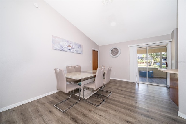 dining room with hardwood / wood-style floors and high vaulted ceiling