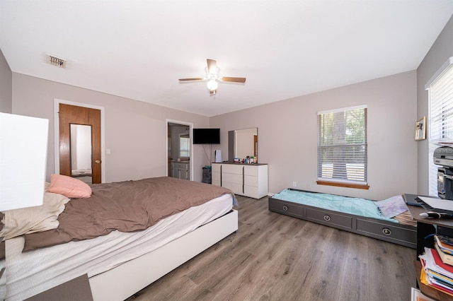 bedroom featuring ensuite bath, light hardwood / wood-style flooring, and ceiling fan