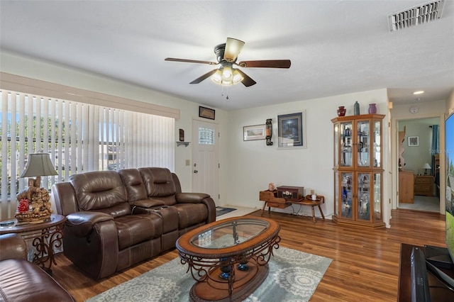 living room with ceiling fan and dark wood-type flooring