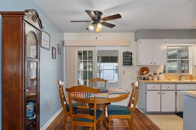 dining area featuring sink, light wood-type flooring, and ceiling fan