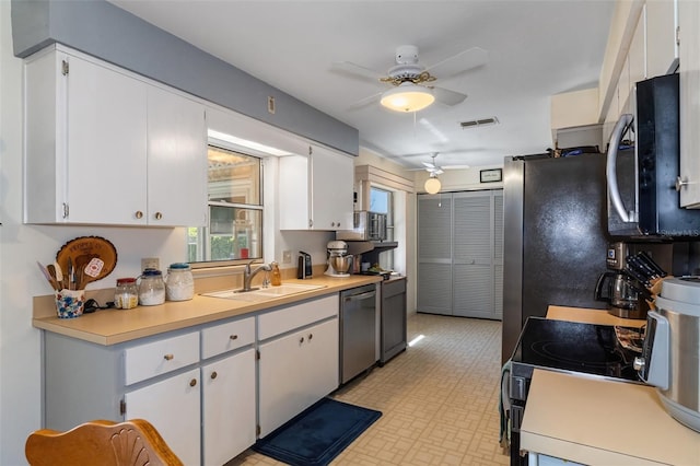 kitchen with ceiling fan, sink, stainless steel appliances, and white cabinets