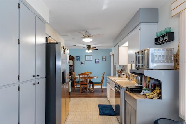 kitchen with sink, white cabinets, stainless steel appliances, and ceiling fan