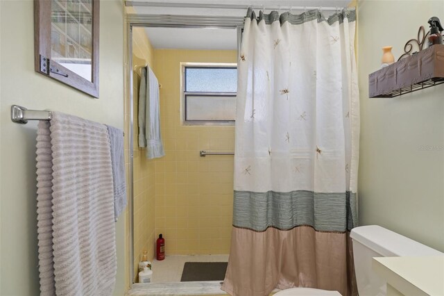 bathroom with toilet and curtained shower