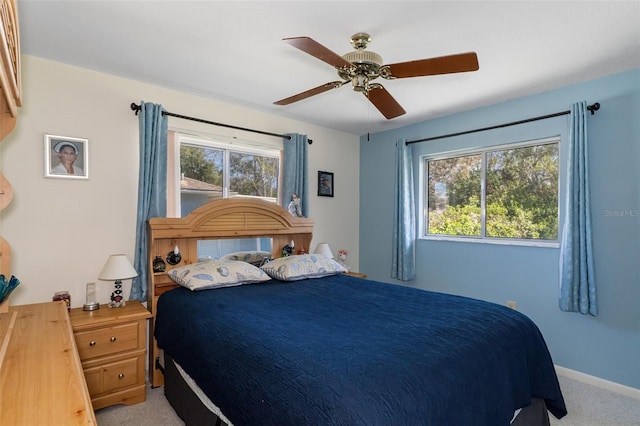 carpeted bedroom with ceiling fan and multiple windows