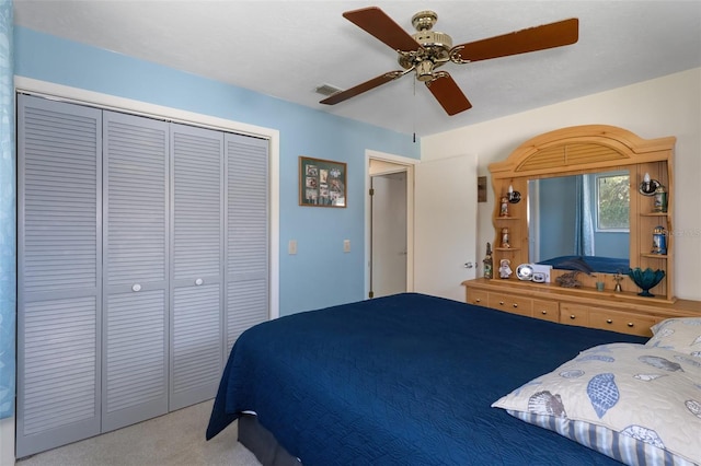 carpeted bedroom featuring ceiling fan and a closet