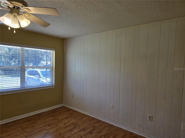 unfurnished room featuring ceiling fan, a textured ceiling, baseboards, and wood finished floors