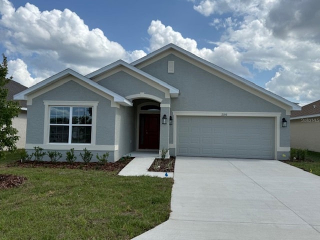 ranch-style home featuring a garage, concrete driveway, and a front yard