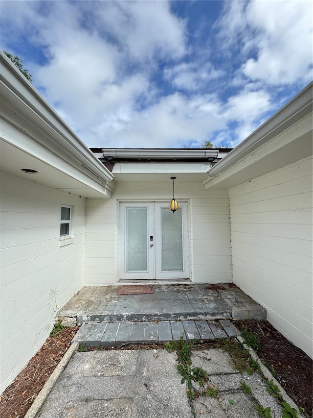 doorway to property featuring concrete block siding, a patio area, and french doors