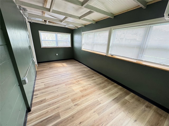 unfurnished sunroom featuring beamed ceiling