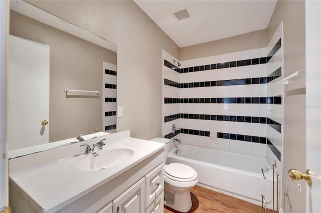 full bathroom with hardwood / wood-style flooring, toilet, vanity, and tiled shower / bath combo