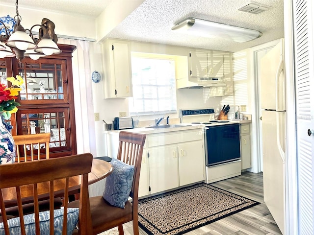 kitchen with white appliances, sink, light wood-type flooring, a textured ceiling, and white cabinets