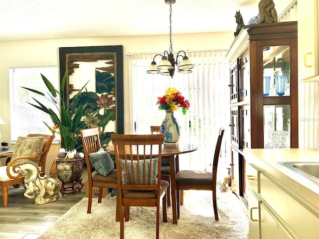 dining room featuring light wood-type flooring and a chandelier