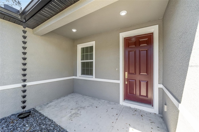 entrance to property featuring stucco siding