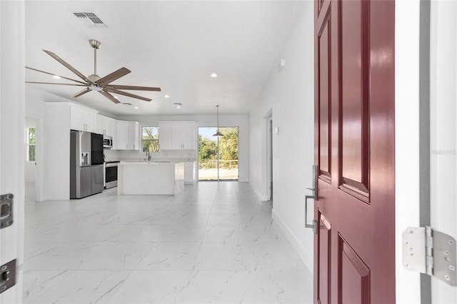 kitchen with marble finish floor, stainless steel appliances, light countertops, visible vents, and white cabinetry