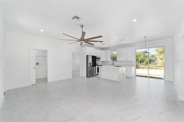 kitchen with stainless steel appliances, visible vents, white cabinetry, light countertops, and marble finish floor