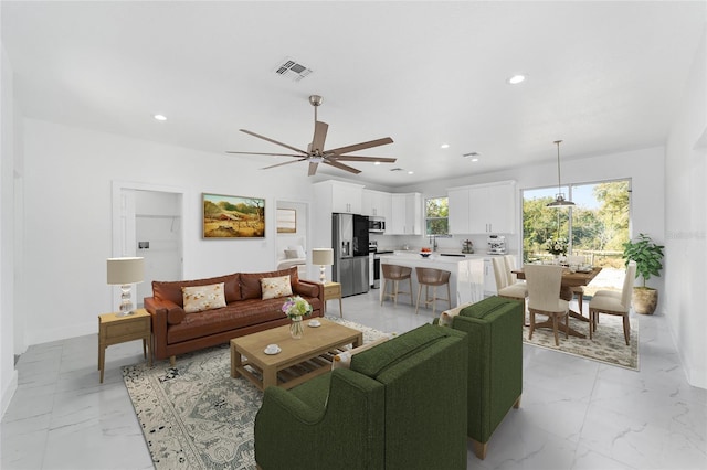 living room with baseboards, visible vents, a ceiling fan, marble finish floor, and recessed lighting