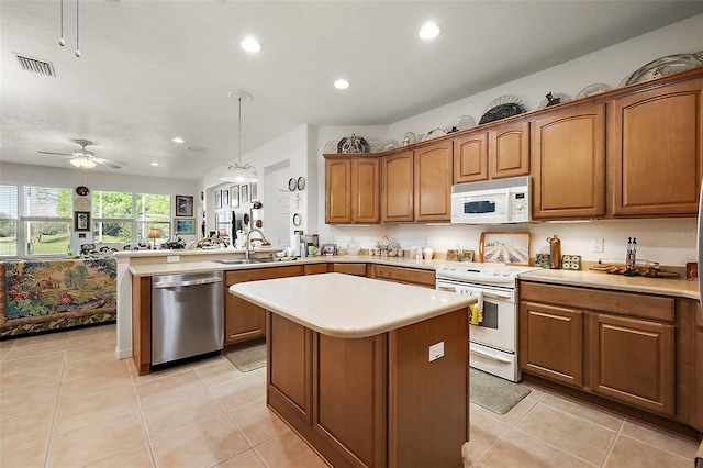 kitchen with white appliances, visible vents, a kitchen island, a peninsula, and light countertops