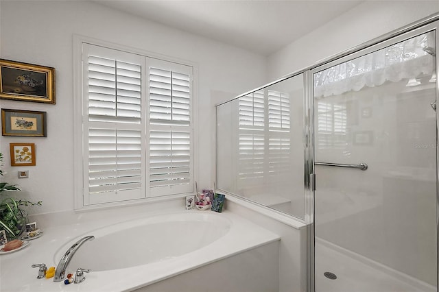 full bathroom featuring a garden tub and a shower stall