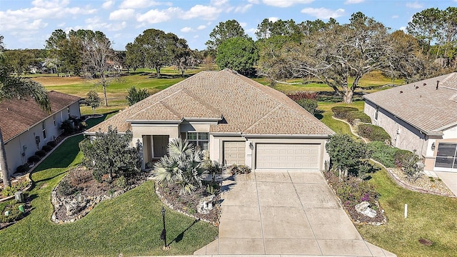 view of front of home with a garage, driveway, a shingled roof, a front lawn, and stucco siding