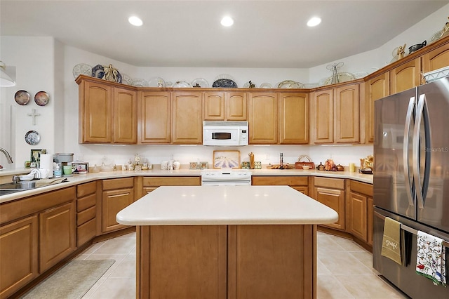 kitchen with white microwave, freestanding refrigerator, light countertops, a sink, and range with electric stovetop