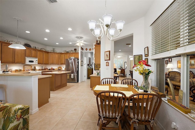 dining space with ceiling fan with notable chandelier, recessed lighting, and light tile patterned floors