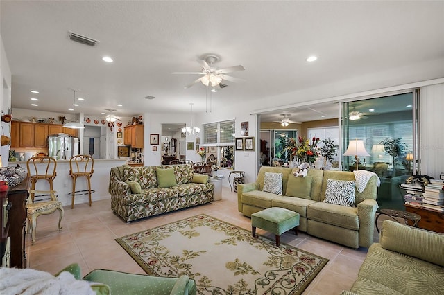 living room with light tile patterned floors, recessed lighting, visible vents, and ceiling fan with notable chandelier