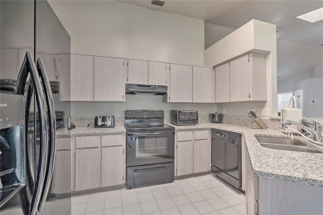 kitchen featuring light tile patterned floors, under cabinet range hood, light countertops, black appliances, and a sink