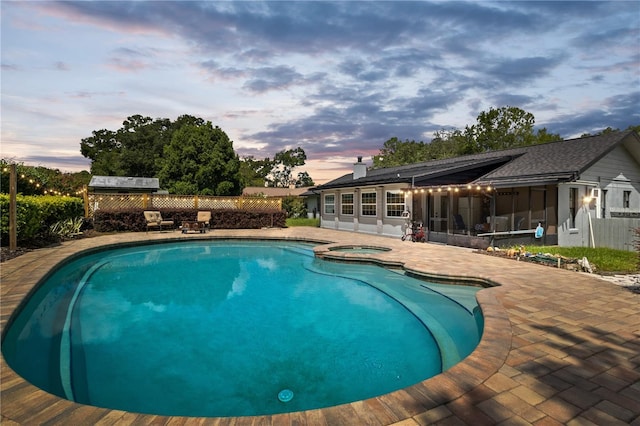 view of pool with a patio, a pool with connected hot tub, and a sunroom