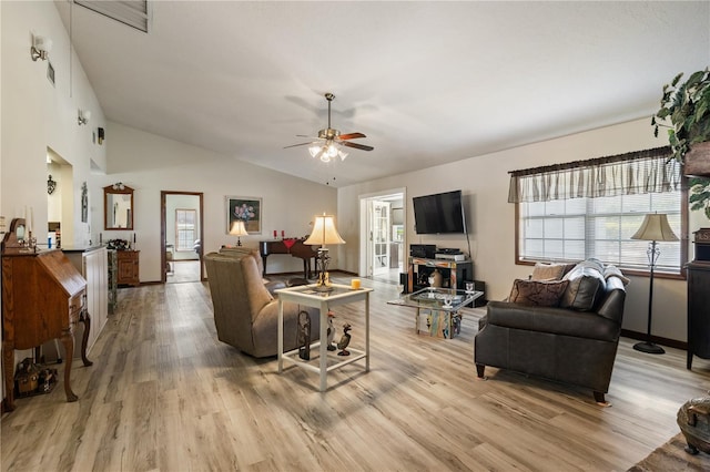 living room featuring lofted ceiling, light wood-style flooring, and ceiling fan