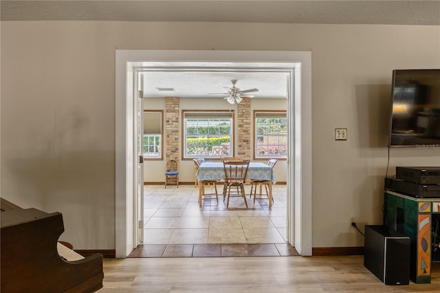 dining space with baseboards, visible vents, ceiling fan, a textured ceiling, and light wood-style floors