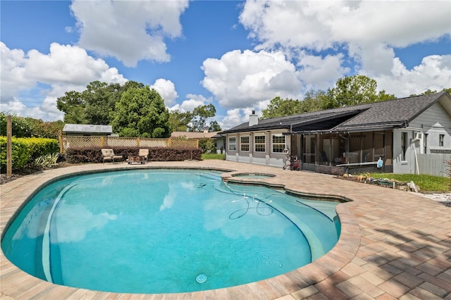 view of swimming pool with a fenced in pool, a sunroom, a patio area, and an in ground hot tub