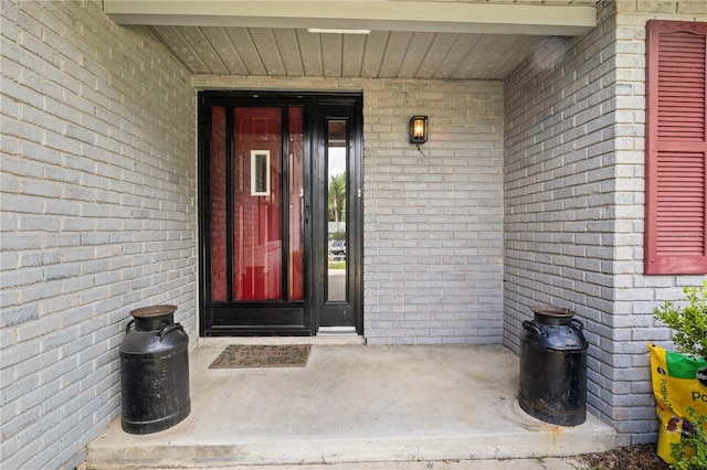 entrance to property featuring brick siding