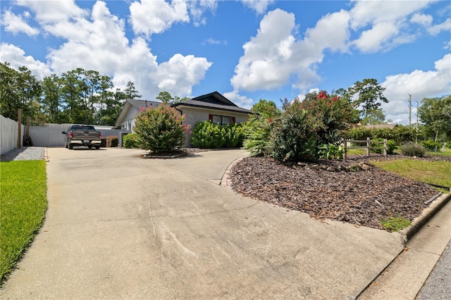 view of front of house featuring concrete driveway and fence