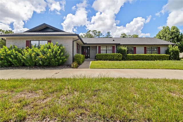 ranch-style home featuring brick siding and a front yard